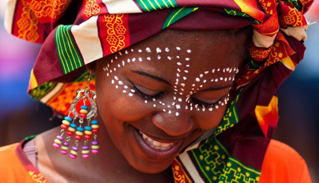 moça negra com turbante sorrindo